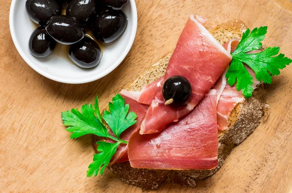 Тапас з беконом, хлібом, зеленню та оливками — стокове фото