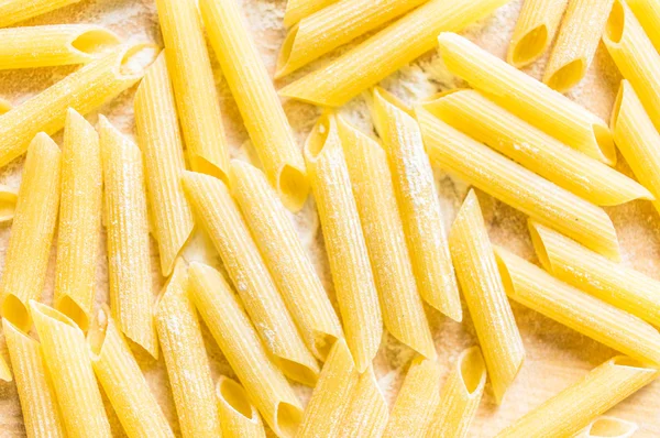 Macaroni in flour on the table for background — Stock Photo, Image