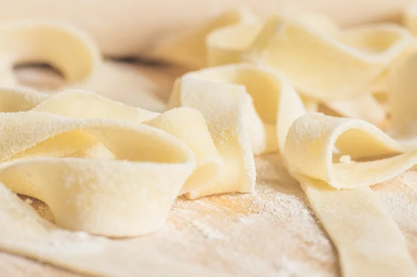 Fettuccini pasta dough in flour with a rolling pin for cooking — Stock Photo, Image