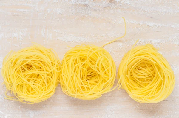 Capellini pasta nests on the board — Stock Photo, Image