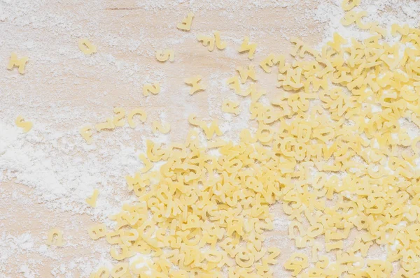 Background of scattered alphabet pasta — Stock Photo, Image