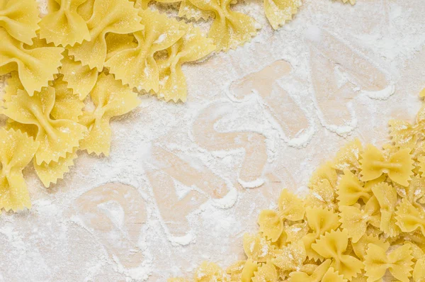Inscription on the flour word pasta — Stock Photo, Image