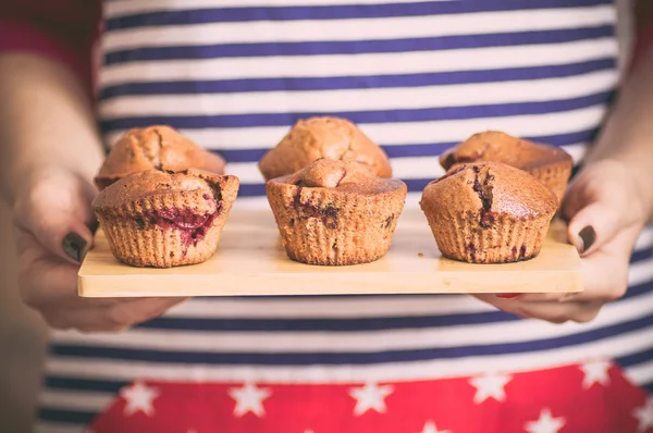 Housewife brings a plate with muffins — Stock Photo, Image