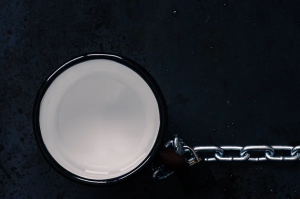 Tasse avec les restes d'eau avec chaîne en acier — Photo