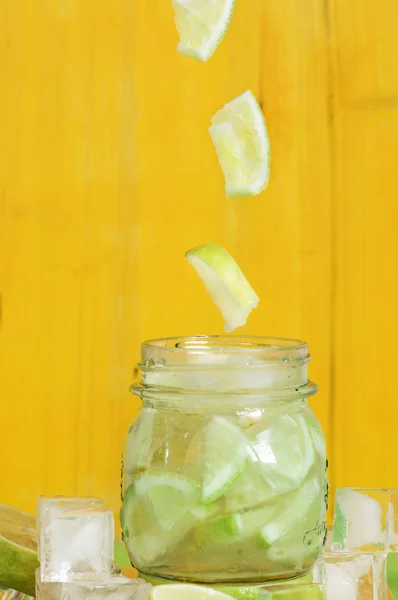 Slice of lemon falling into a glass jar — Stock Photo, Image