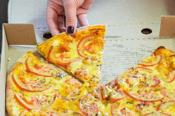 Woman hand takes a slice pizza — Stock Photo, Image