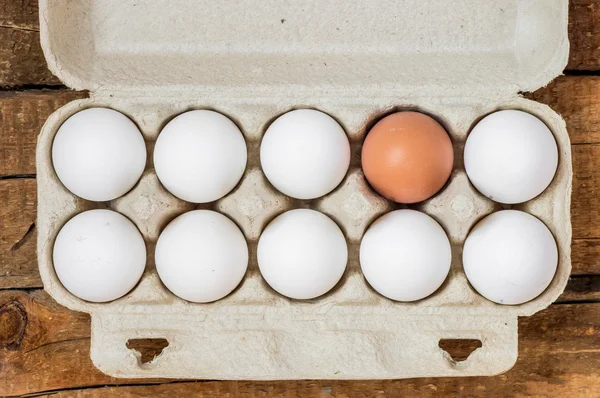 Embalaje huevos blancos y un marrón —  Fotos de Stock
