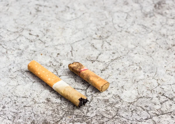 Tapa de cigarrillo desechada en el suelo de cemento —  Fotos de Stock