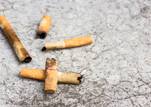 Tapa de cigarrillo desechada en el suelo de cemento —  Fotos de Stock