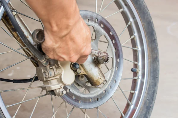 Chave de mão segurando com reparação de motocicleta — Fotografia de Stock