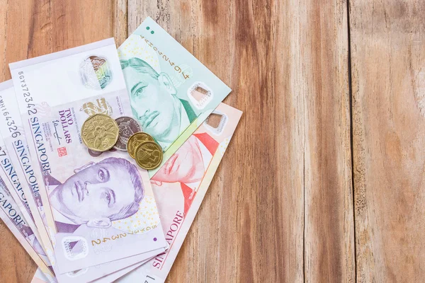 Singapur dinero sobre fondo de mesa de madera — Foto de Stock