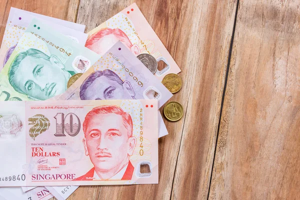 Singapur dinero sobre fondo de mesa de madera — Foto de Stock