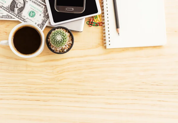 Vintage office desk with notebooks,cactus,smart phone and a cup