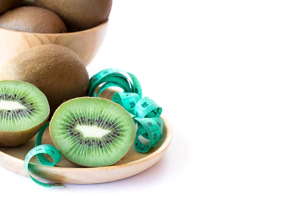 Verse kiwi en meetlint in houten pate — Stockfoto