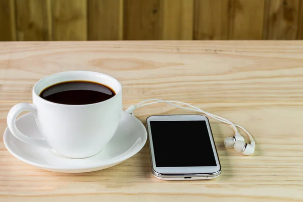 Chytrý telefon a kávy na dřevěný stůl — Stock fotografie
