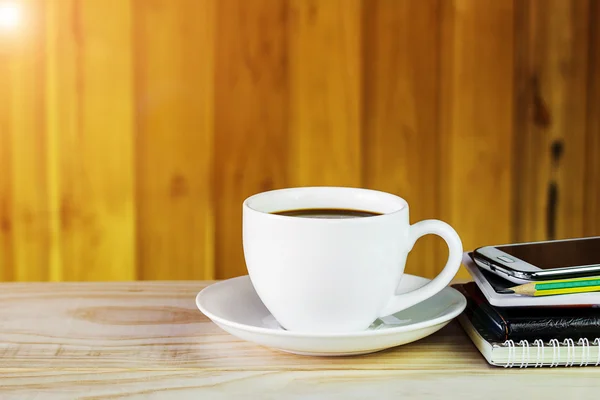 Coffee cup,smart phone and note book on wooden table background — Stock Photo, Image