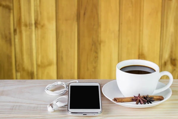 Chytrý telefon a kávy na dřevěný stůl — Stock fotografie