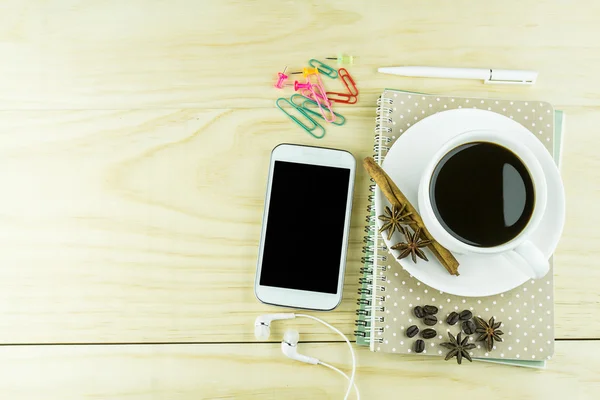 Smart phone, coffee,glasses and book blank with white pen on woo