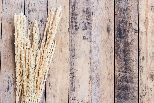 Orejas de trigo sobre un fondo de madera marrón — Foto de Stock