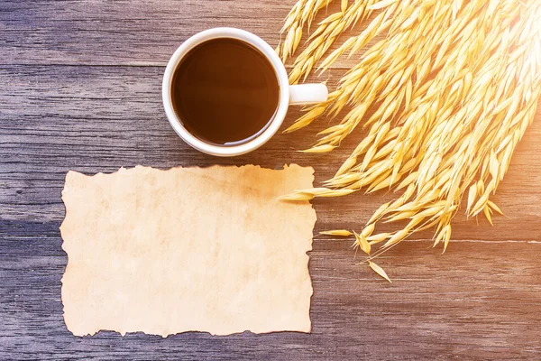 Orelhas de trigo e papel velho em mesa de madeira escura — Fotografia de Stock