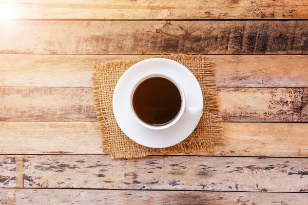 Cup of coffee on old wooden table background — Stock Photo, Image