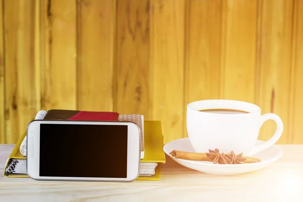 Teléfono inteligente, taza de café y pila de libro sobre mesa de madera —  Fotos de Stock