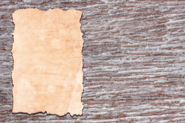 Old paper on brown aged wood — Stock Photo, Image