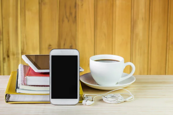Telefone inteligente, xícara de café e pilha de livro na mesa de madeira — Fotografia de Stock