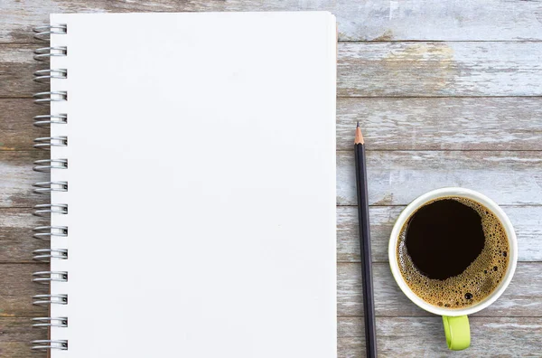 木製のテーブルの上にコピースペース付きの鉛筆とコーヒーカップが付いている空白のメモ帳 目標と目的の概念をリストアップする — ストック写真