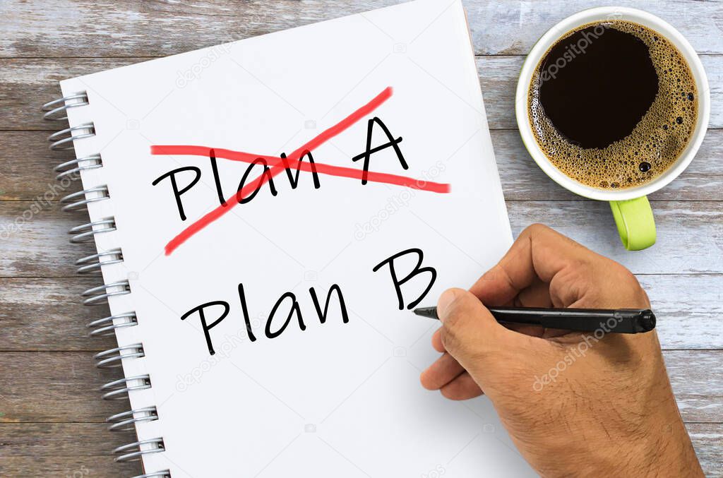 Crossing out Plan A and writing Plan B concept for change of plan. Hand writing plan A and plan B on notebook with coffee