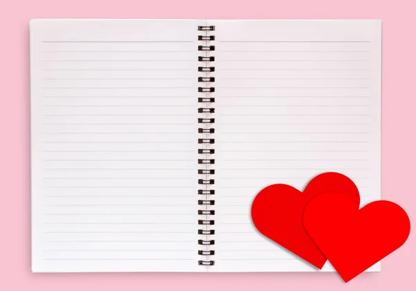 コピースペース付きピンクの背景トップビューに隔離された空白のオープンブック上の赤い紙の心 愛とバレンタインデーのコンセプト — ストック写真
