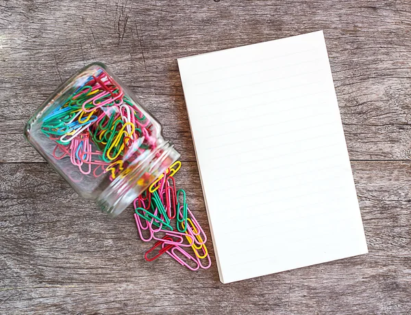 Lege notitieblok openen met paperclips op een houten achtergrond. — Stockfoto