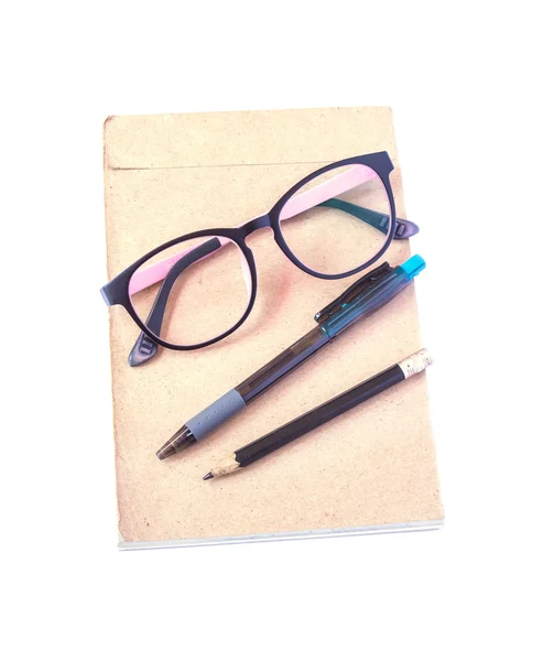 Glasses, pen and pencil put on brown paper. With a white backgro — Stock Photo, Image