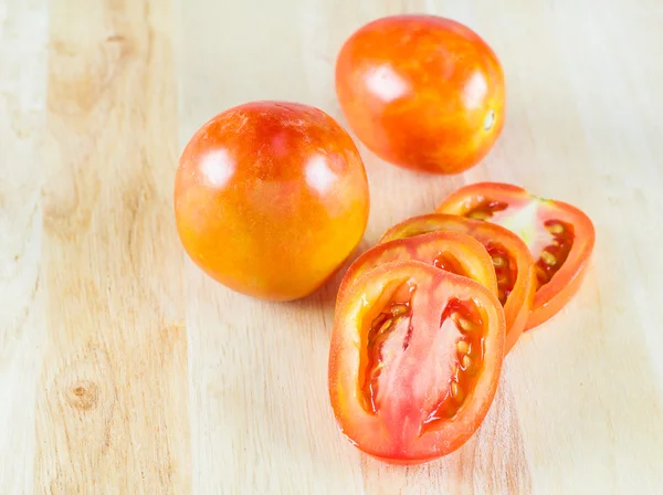 Trancher la tomate sur une planche à découper en bois — Photo