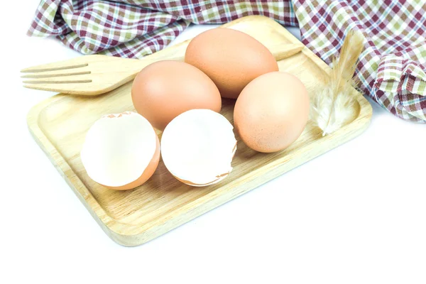 Close-up van ei op tabel doek in houten plaat op witte achtergrond — Stockfoto