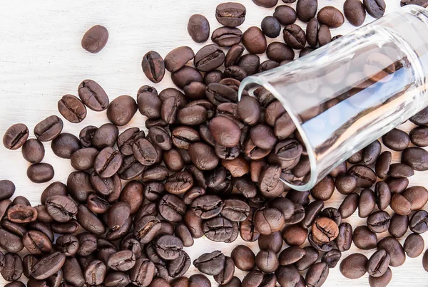 Kaffebönor i ett glas på trä — Stockfoto