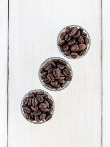 Granos de café en un vaso de madera — Foto de Stock