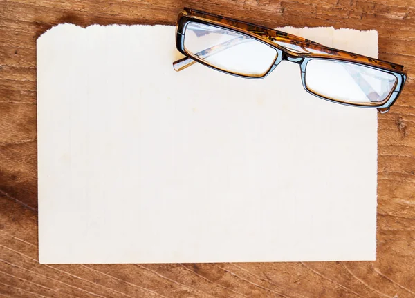 Papel viejo y vasos sobre fondo de madera — Foto de Stock