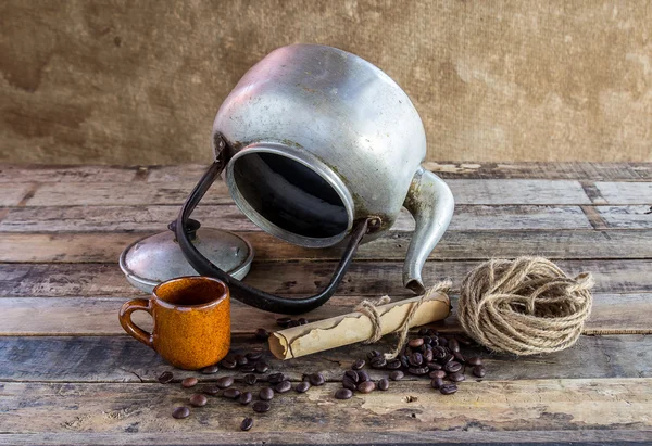 Old kettle,paper roll,rope reel and coffee beans on wooden backg — Stock Photo, Image