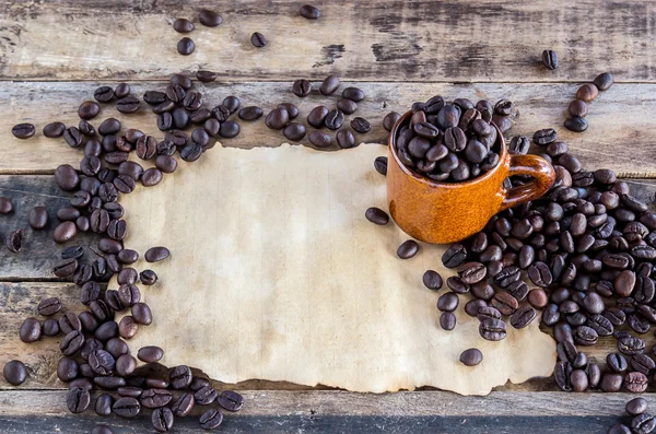 Papel viejo y granos de café en madera — Foto de Stock