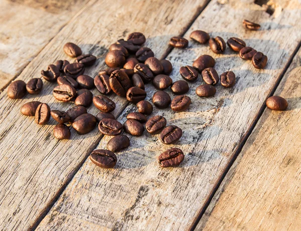 Kaffebönor på träbord — Stockfoto