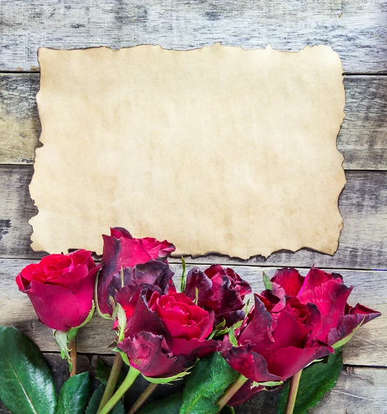 Trandafir roșu proaspăt și hârtie veche pe fundal din lemn — Fotografie, imagine de stoc