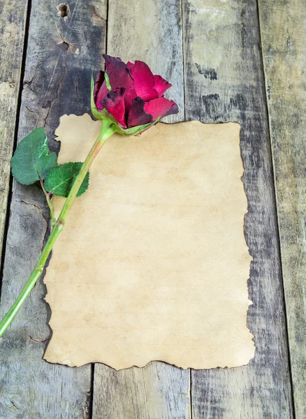 Frische rote Rose und altes Papier auf Holzgrund — Stockfoto