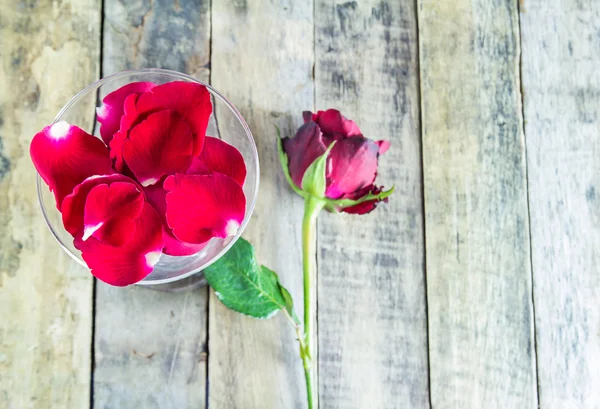 Rosa roja fresca en vidrio sobre fondo de madera —  Fotos de Stock