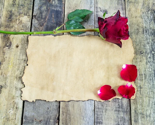 Rosa roja fresca y papel viejo sobre fondo de madera —  Fotos de Stock