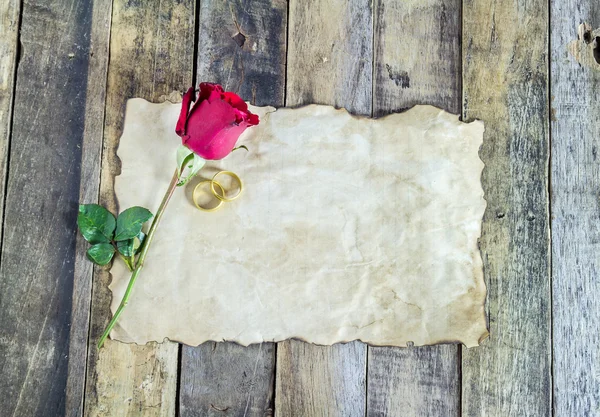 Nahaufnahme Goldring, rote Rose und altes Papier auf Holz — Stockfoto