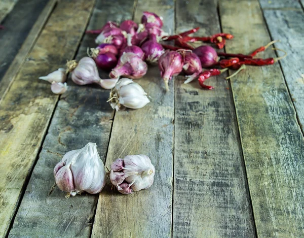 Nahaufnahme von Knoblauch, Zwiebeln und trockenem Pfeffer auf Holztischhintergrund — Stockfoto