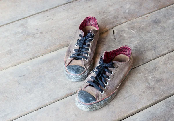 Smutsiga gamla skor på golvet — Stockfoto