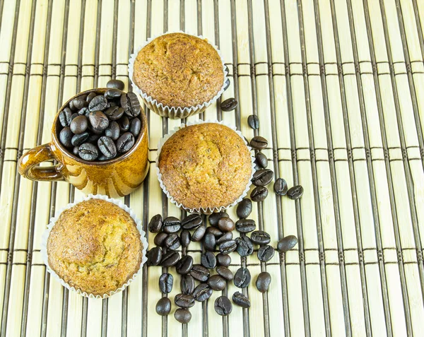 Banana cup cake and coffee beans on wooden background — ストック写真