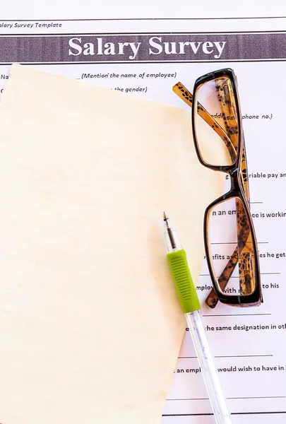 Óculos e caneta no inquérito salarial de — Fotografia de Stock